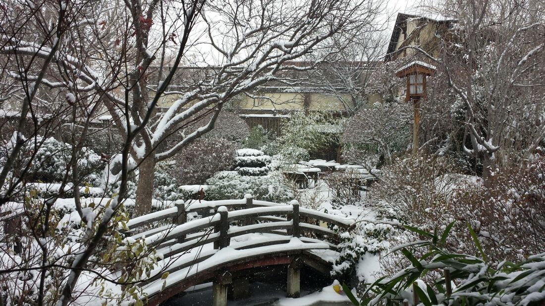 The DOMO garden in winter, snow on the wooden bridge and lanterns