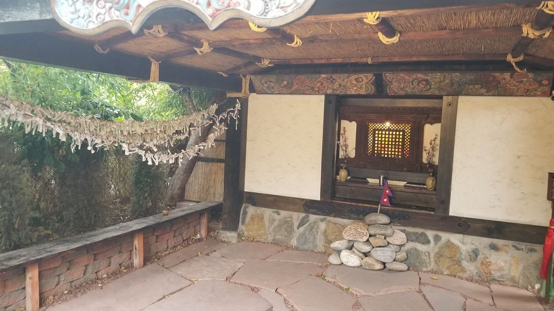 The Musubido, a small shrine hall of stone and timber with a thatched roof, in the DOMO garden